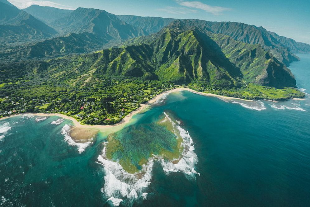 Kauai in Hawaii aus der Luft fotografiert, grüne hügelige Landschaft und türkisfarbener Ozean